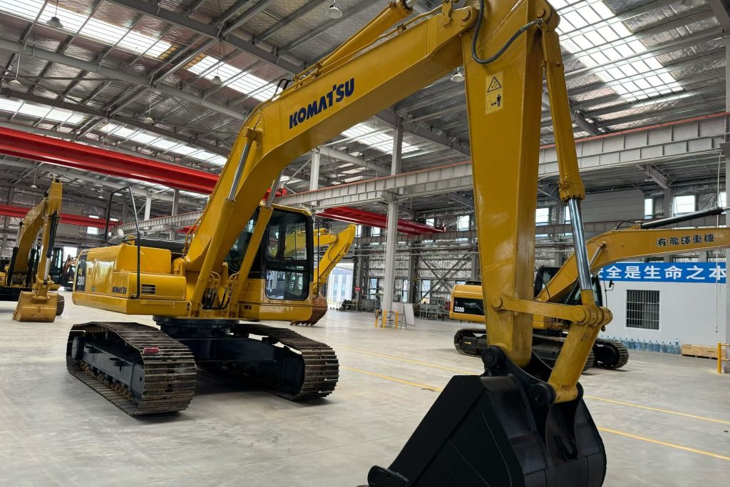 Used Komatsu excavator inside a machinery refurbishment workshop