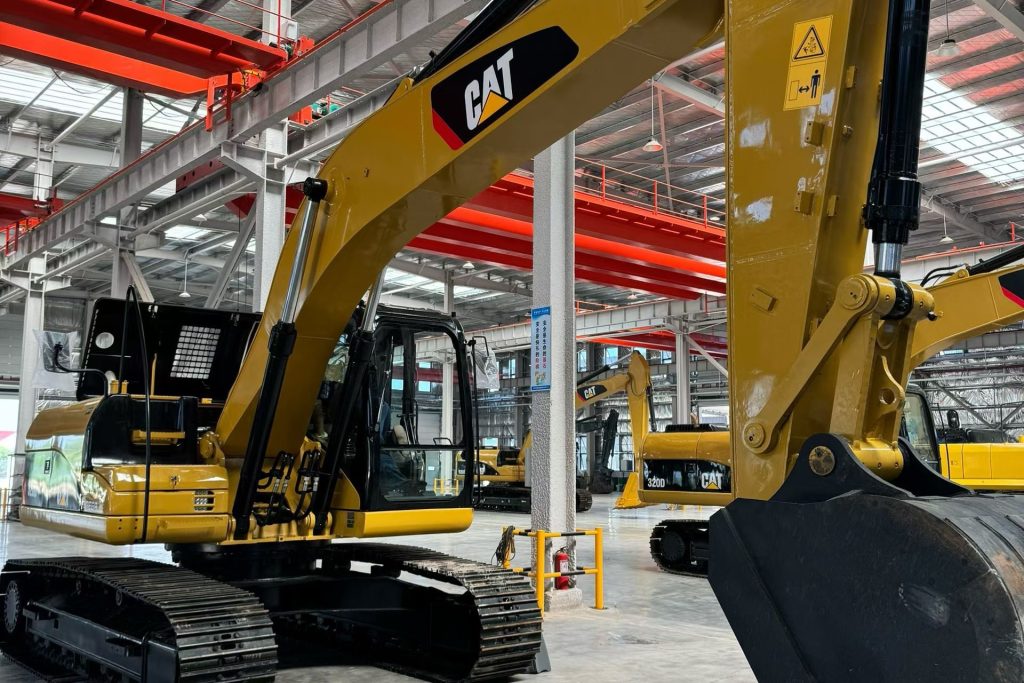 Used Caterpillar excavator at a machinery refurbishment workshop